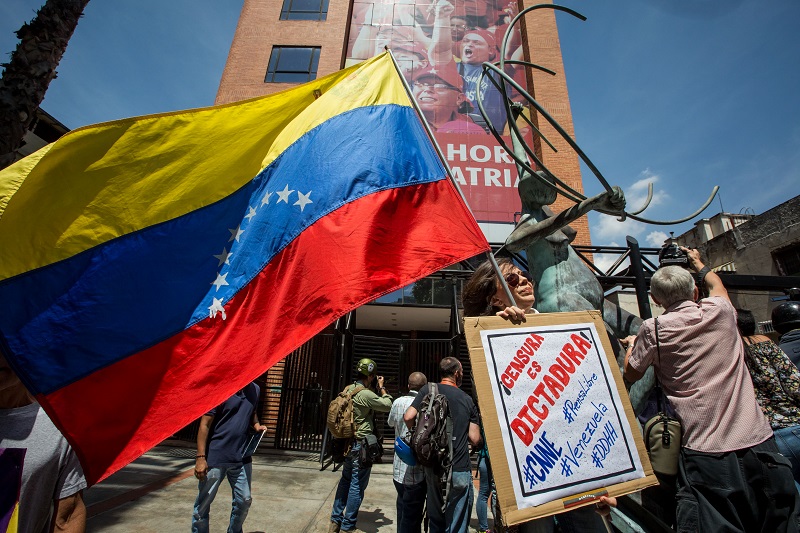 Demonstrators protest outside the National Telecommunications Commission after the government took the channel CNN en Espanol off the air in Caracas, Venezuela, 16 February 2017.